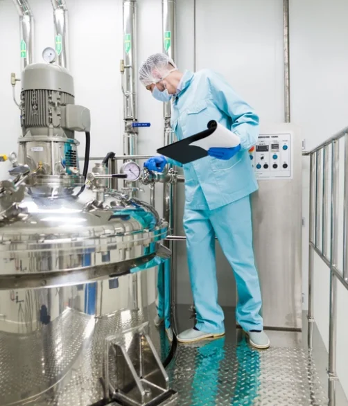 Pracownik przy analizie bhp maszyny do produkcji kosmetyków - pomiary środowiska pracy